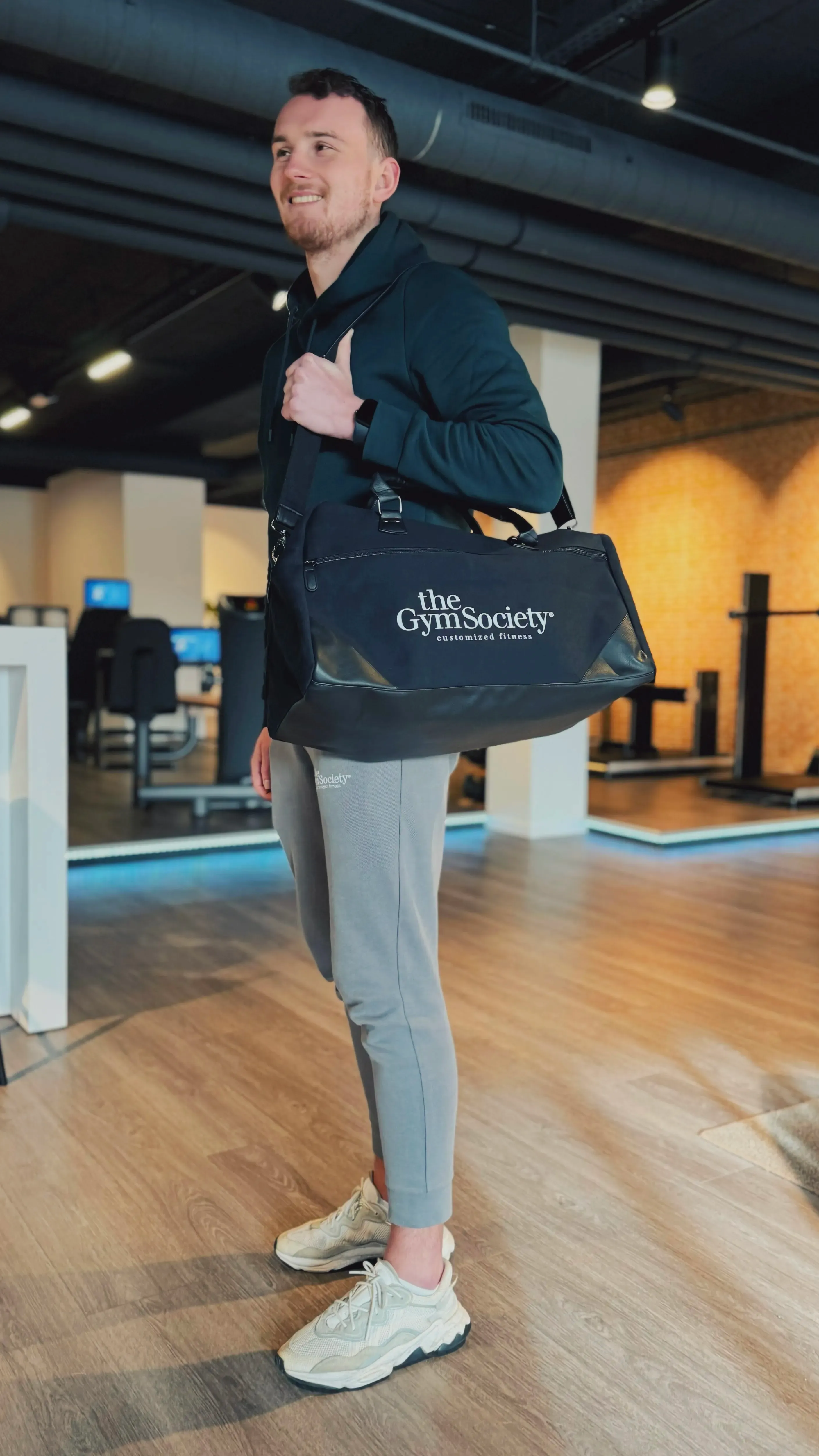 Man met The Gym Society sporttas in luxe boutique gym