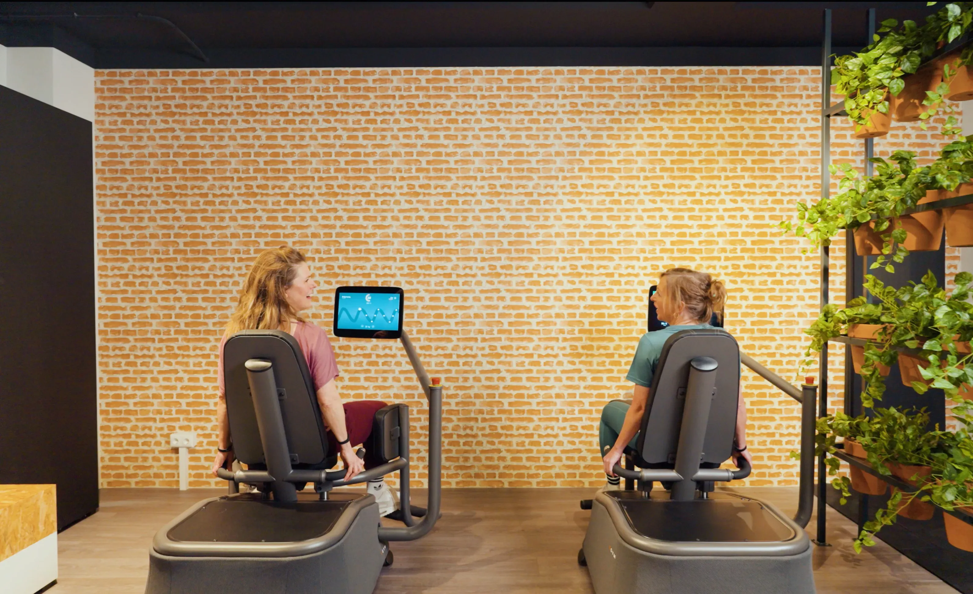 Twee vrouwen sporten samen op slimme krachttoestellen