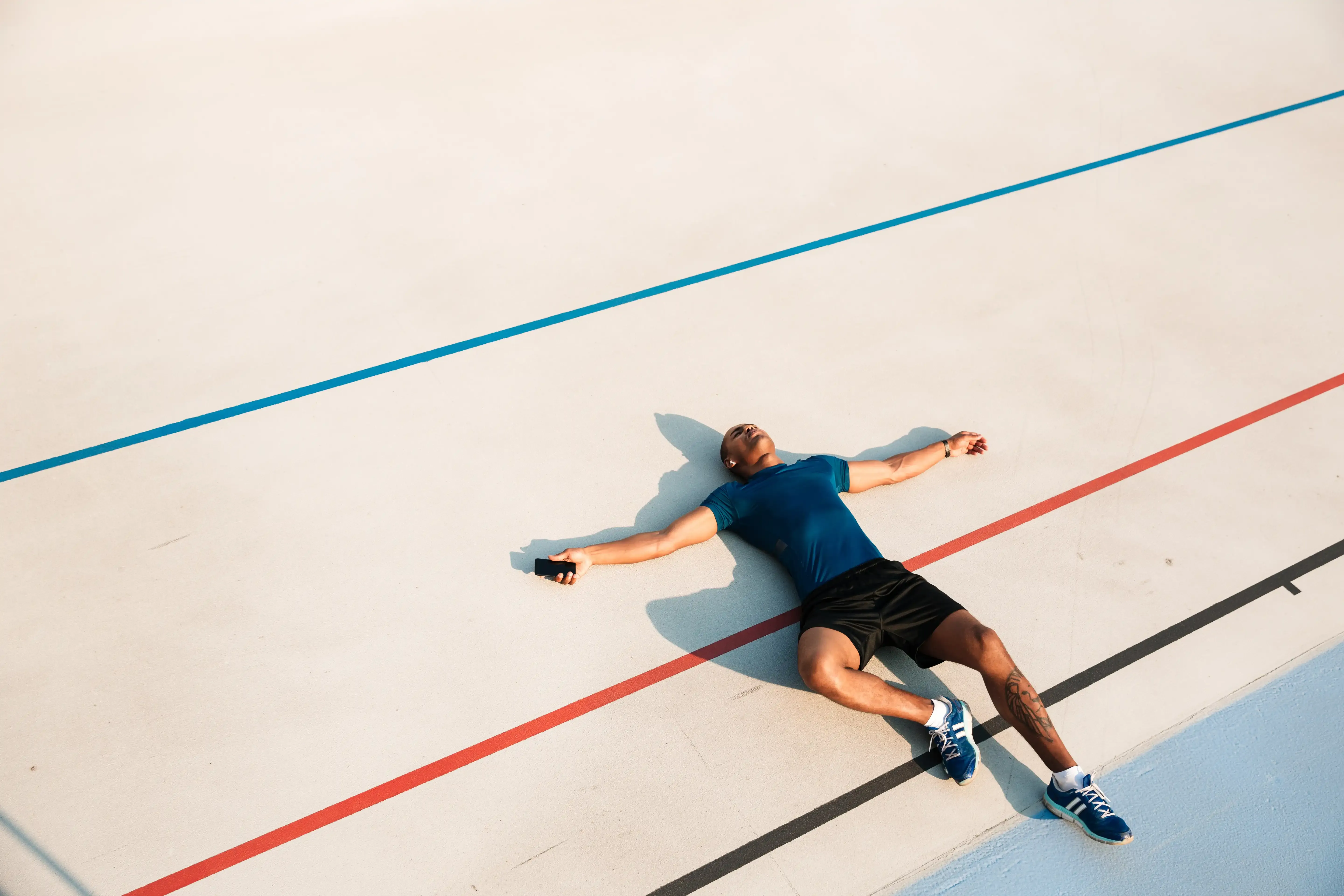 Man ligt uitgeput op de grond na een intensieve workout