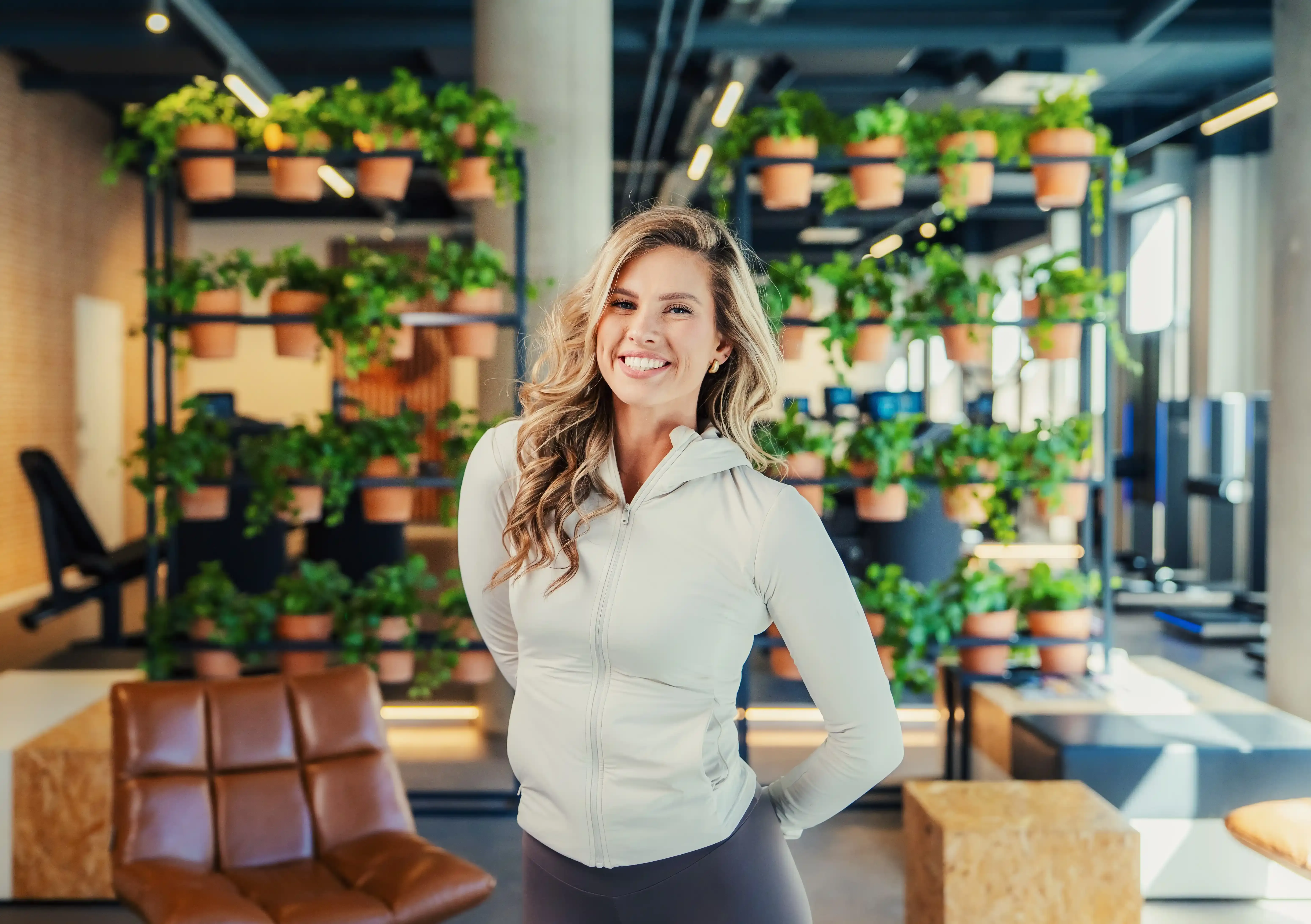 Vrouw poseert lachend in de studio van The Gym Society