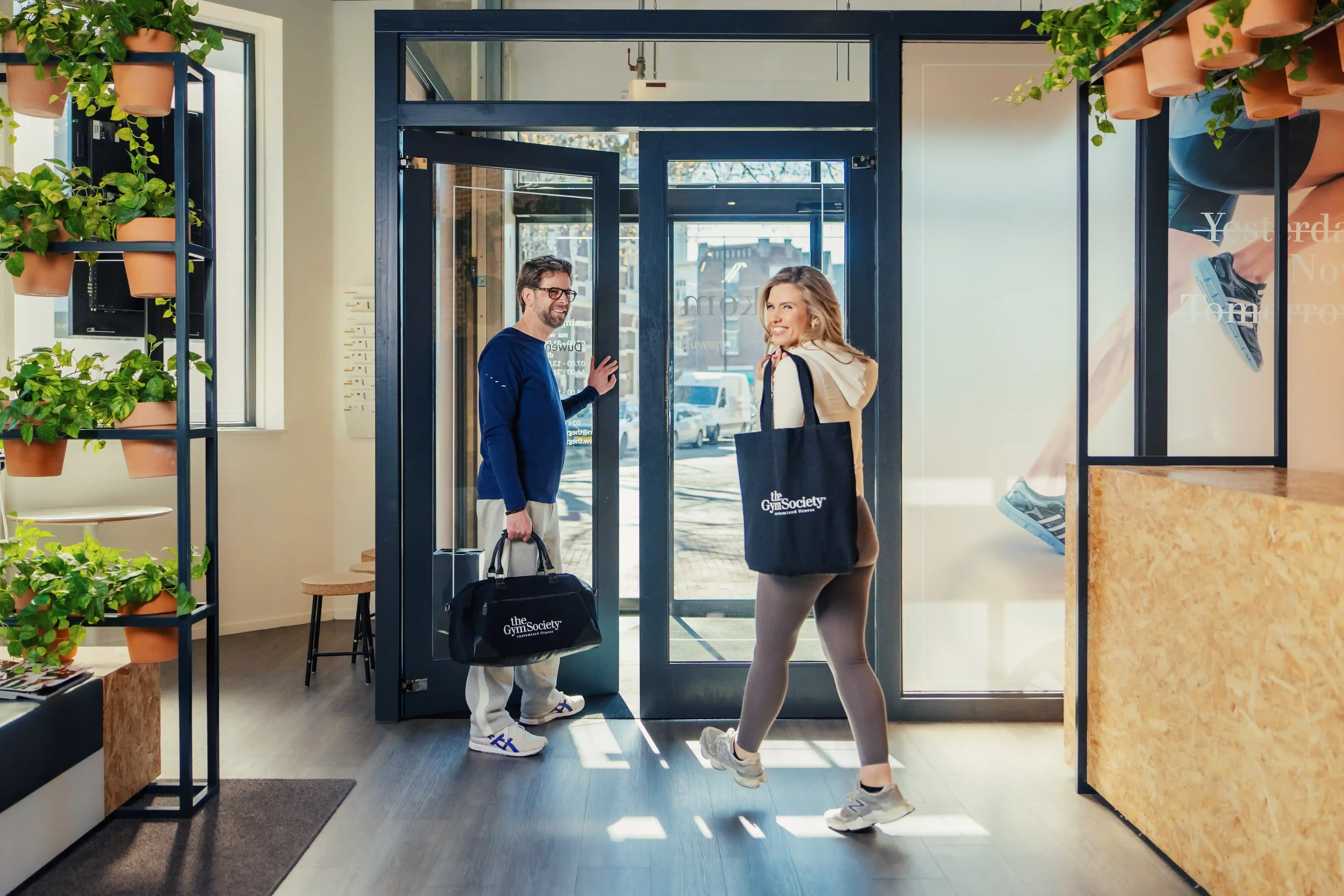 Twee leden lopen met een glimlach de studio uit