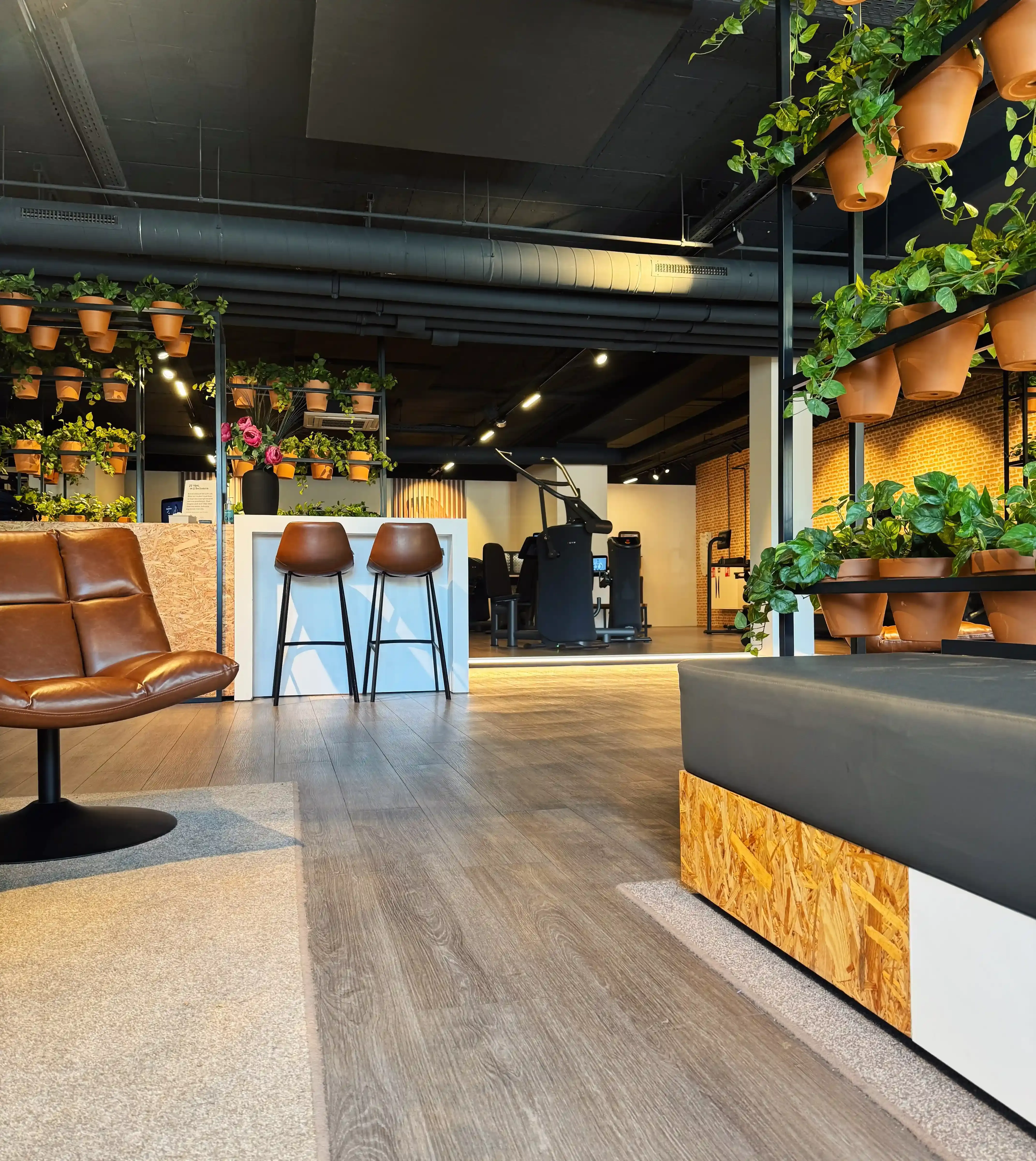 Overzicht van lege lounge en trainingsruimte in The Gym Society studio