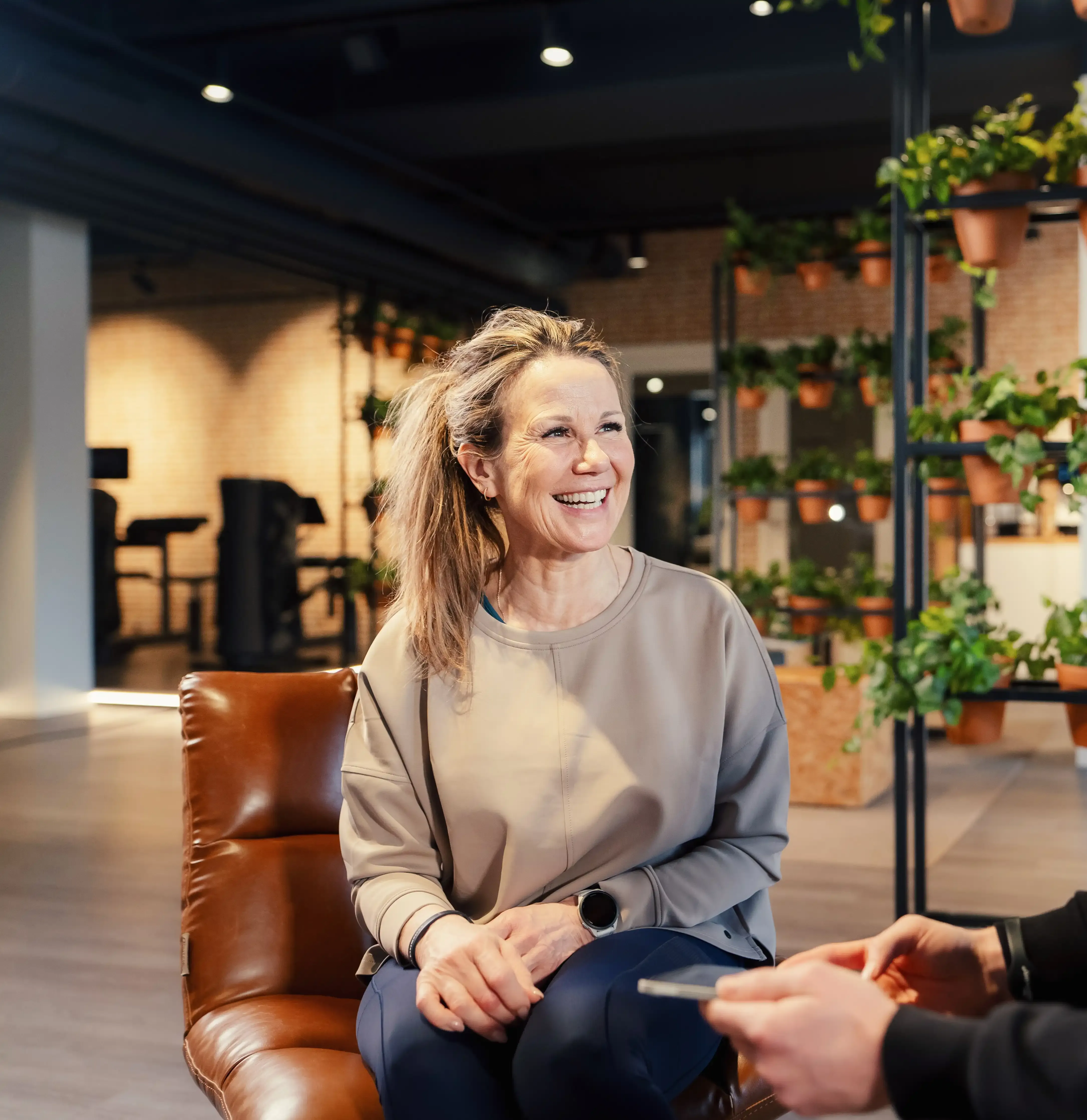 Lid zit lachend in de lounge van The Gym Society