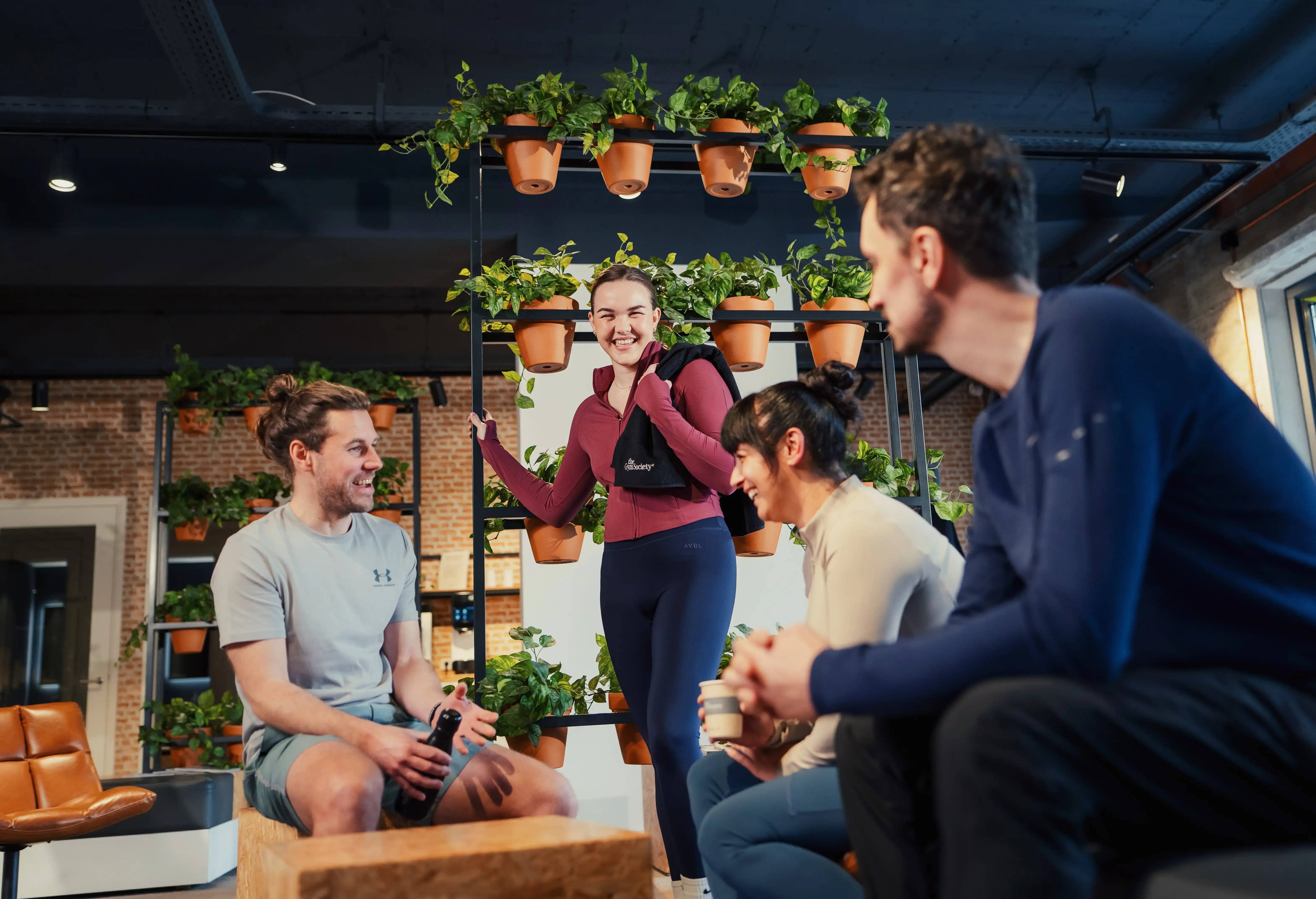 Groep leden staat en zit samen in de lounge en praat met elkaar