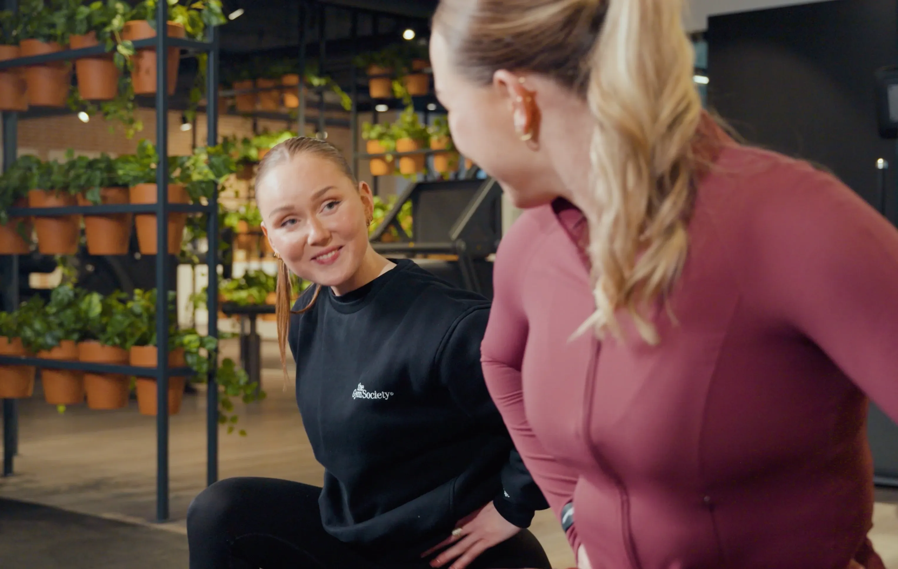 Coach en lid lachen samen tijdens een stretch
