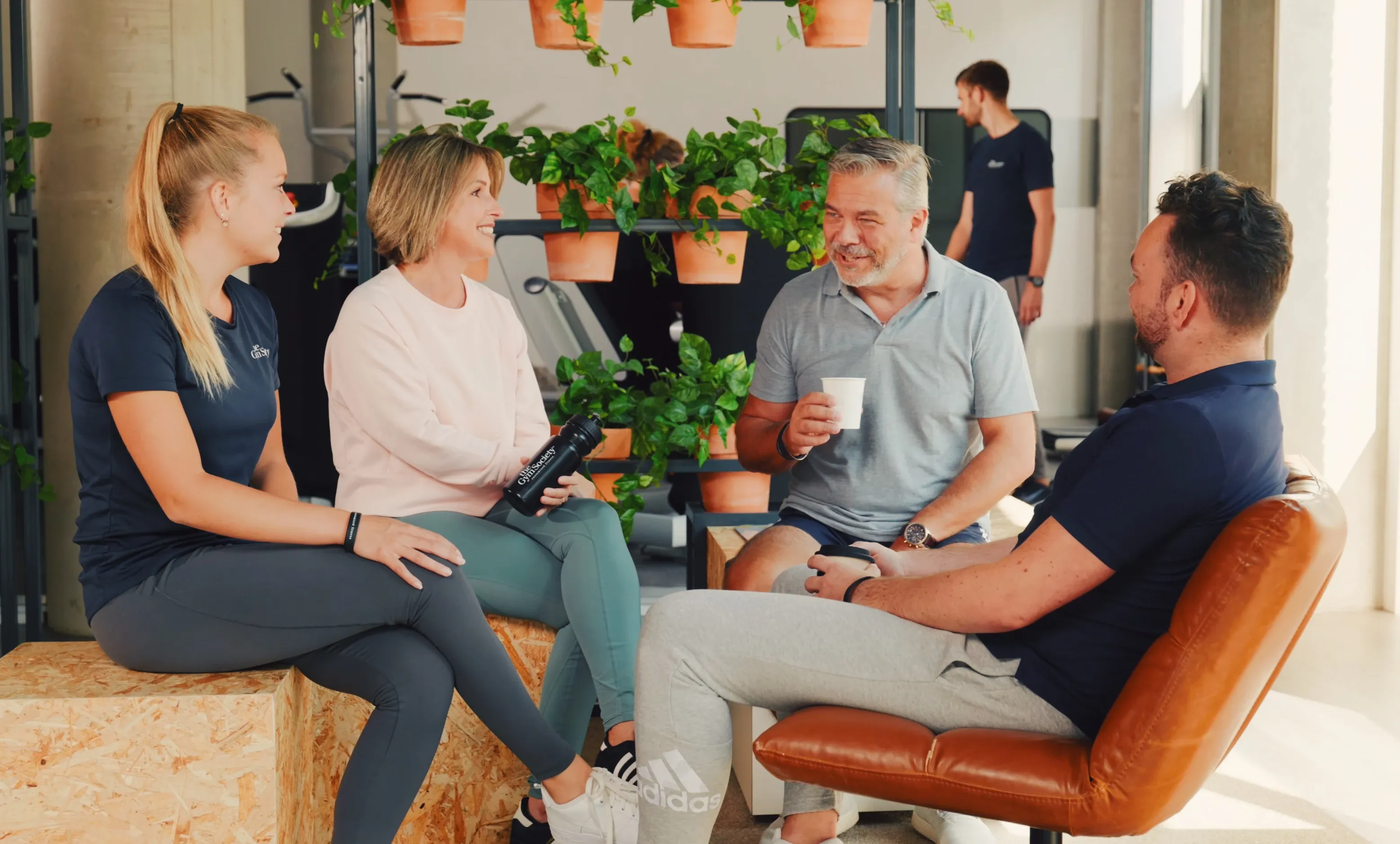 Gezellige sfeer met leden die samen zitten en koffie en water drinken