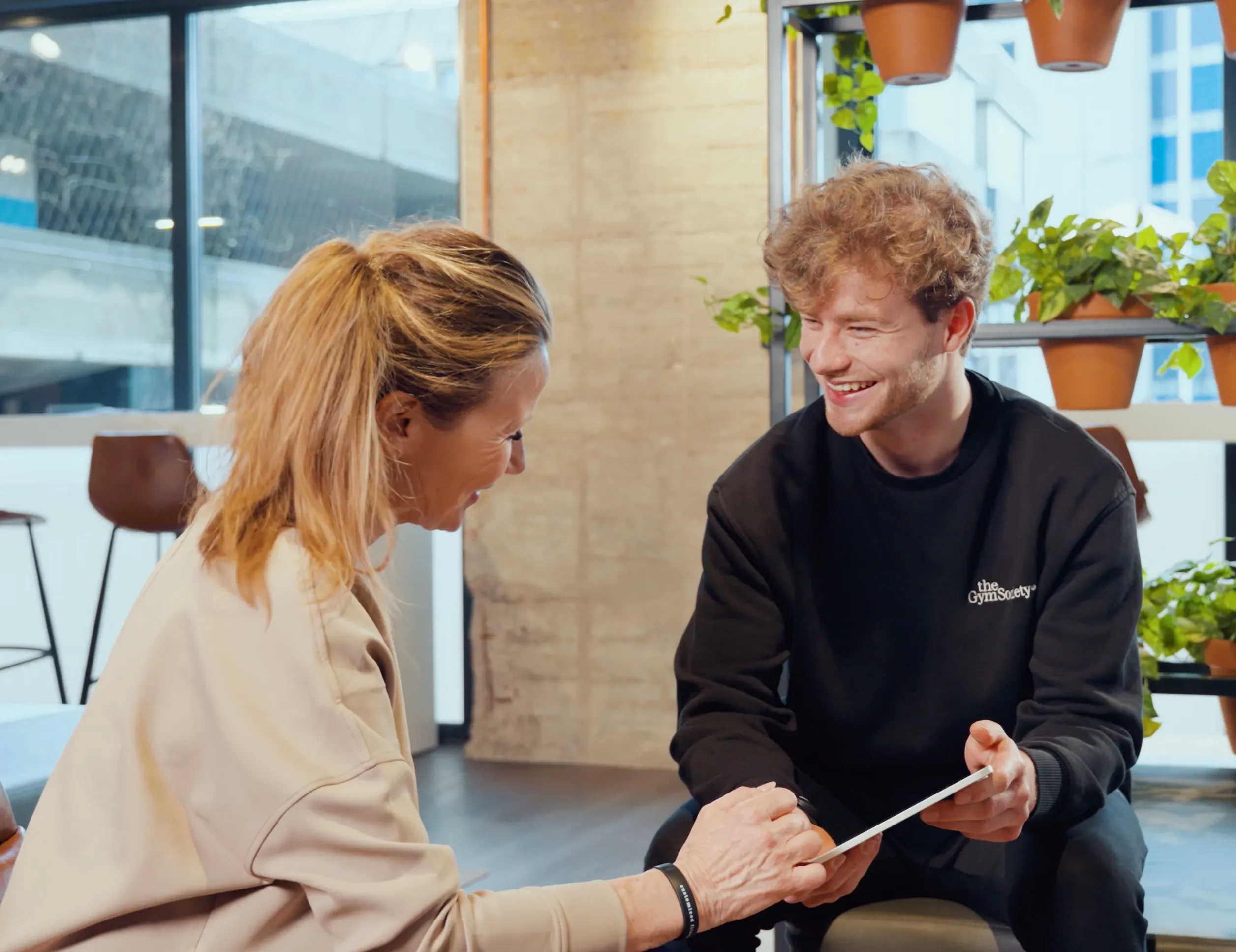 Coach bespreekt voortgang met lid in lounge van The Gym Society