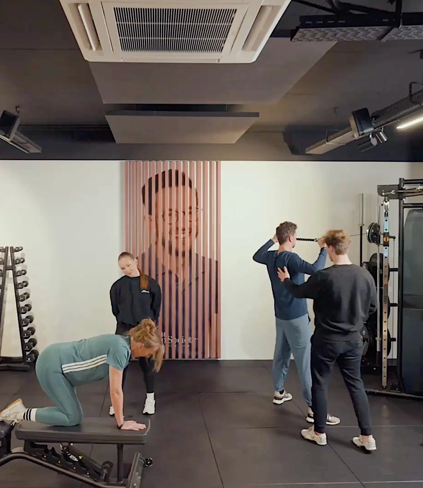 Coaches begeleiden meerdere leden tijdens oefeningen in de trainingsruimte