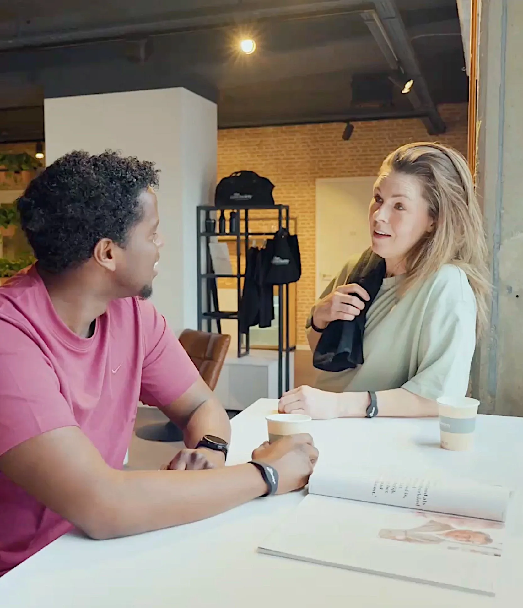 Coach en lid zitten samen aan tafel en bespreken voortgang