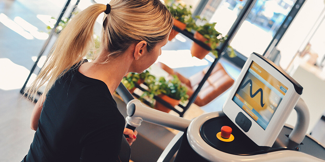 Een vrouwelijk lid dat op een toestel aan het trainen is in The Gym Society