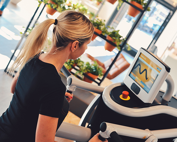 Een vrouwelijk lid dat op een toestel aan het trainen is in The Gym Society