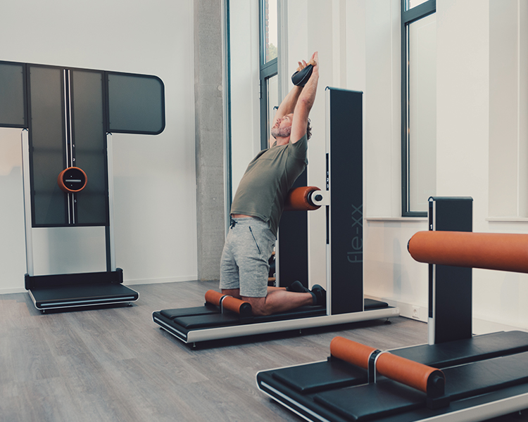 Een mannelijk lid van The Gym Society dat een flexibiliteitstraining aan het volgen is