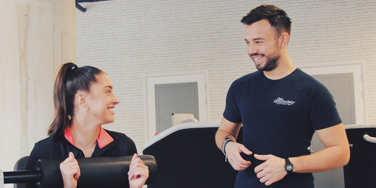 Een Lifestyle Coach en lid van The Gym Society die naar elkaar lachen